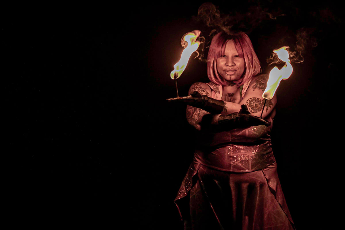 Fire torch performer holding two flames; metal grips with light fabric wraps