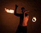 Fire poi set with flaming tips on chains held by performer in a pose
