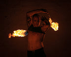 Fire poi set with two flaming tips on chains in a raised-arm pose