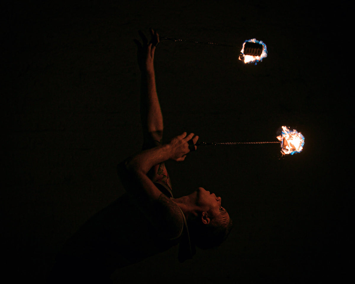 Fire poi set with two flaming tips on chains during performance
