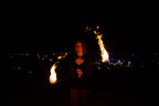 Fire poi with black braided cords and bright flame streams from the tips