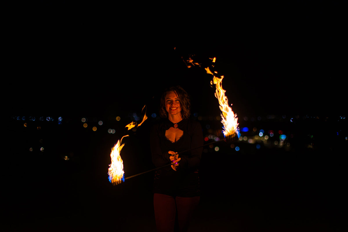 Fire poi with black braided cords and bright flame streams from the tips