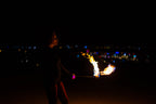 Fire poi with black braided cords and active flame tips during a spin