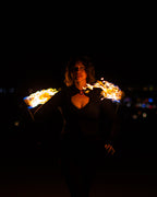 Fire poi in motion with black braided cords and flames glowing around the tips