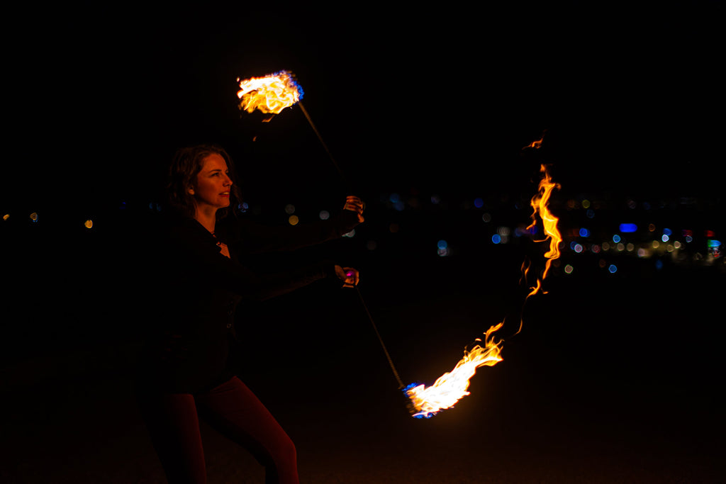 Fire poi with black braided cords and burning flames at the ends