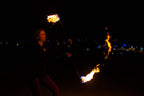 Fire poi with black braided cords and burning flames at the ends