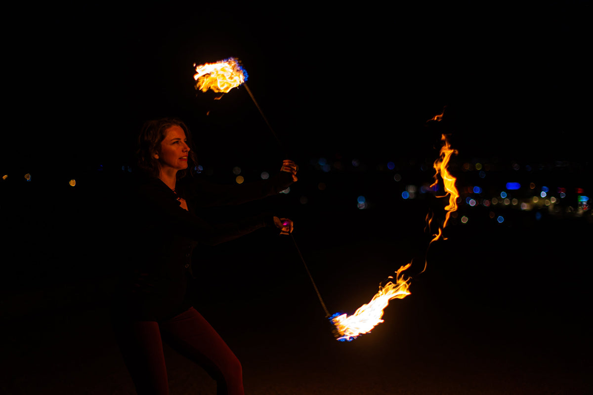 Fire poi with black braided cords and burning flames at the ends