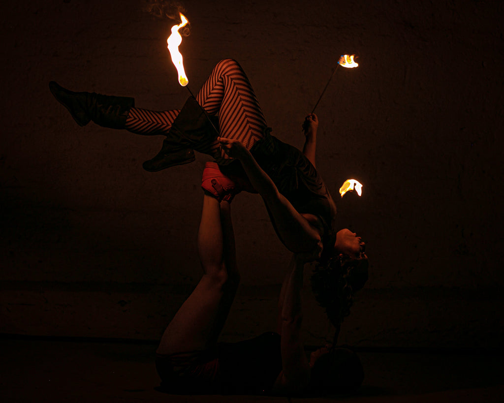 Flaming fire torch held overhead with a burning tip at the woven tan head