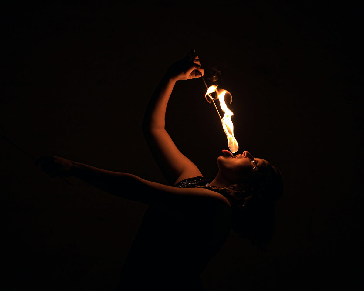 Handheld fire torch with flame at the tan woven head