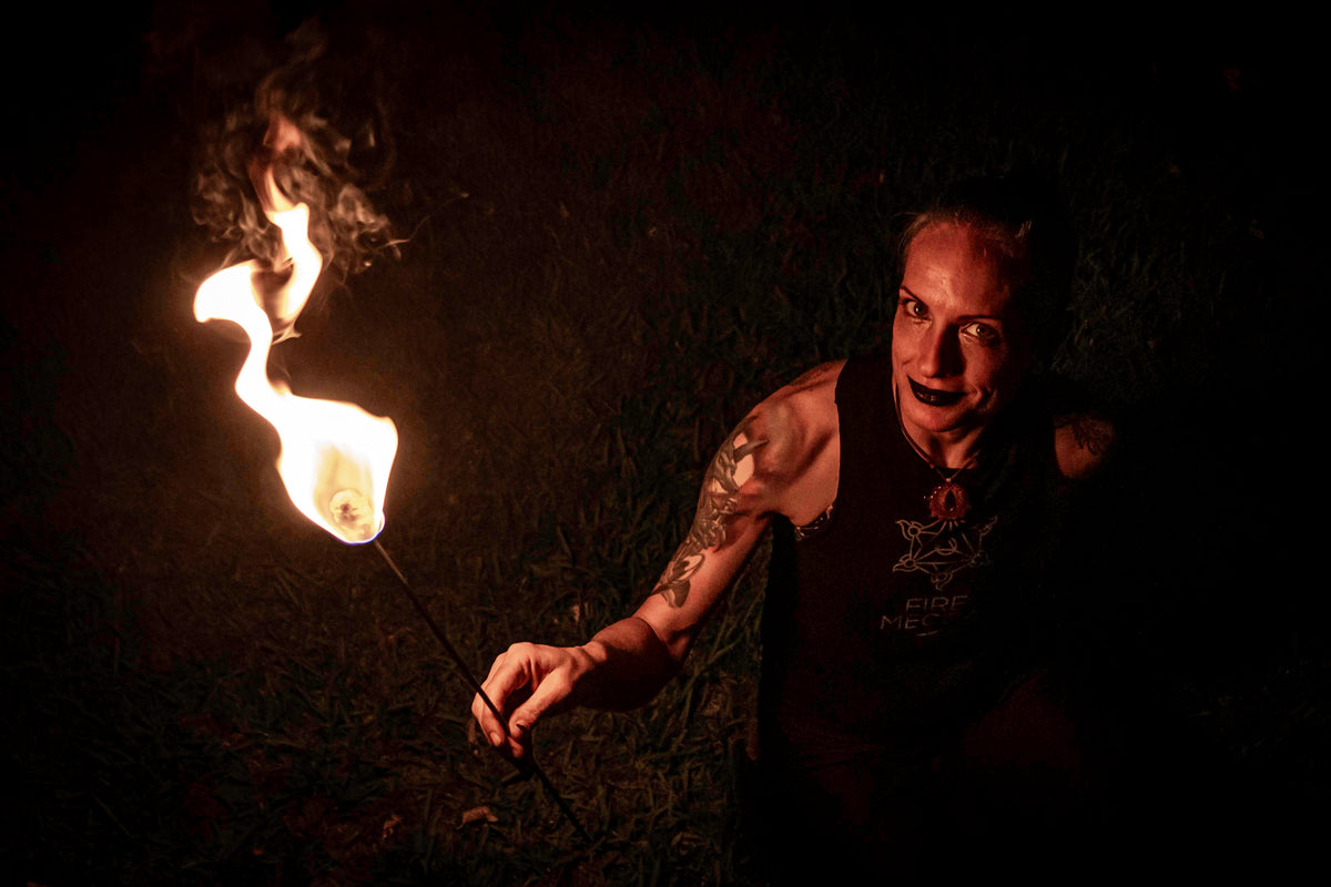 Fire torch in use with a small flame at the tan woven head