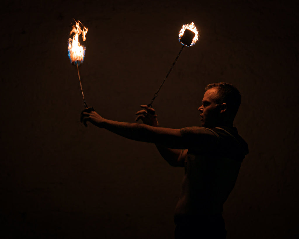 Fire poi set with two flaming wicks on chains, held in motion