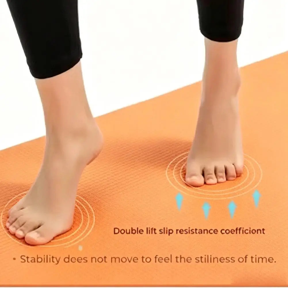 Orange yoga mat close-up under bare feet, showing non-slip grip texture