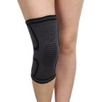 Black knee sleeve on leg with curved black support shapes and ribbed compression panels.