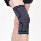 Black knee sleeve with dark curved support shapes and ribbed side paneling.