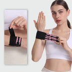 Black wrist support brace with pink logo, worn on wrist with adjustable double bands