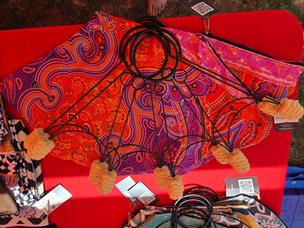 Paisley fan cover with black cord ring stays and orange tassels; product tags included.