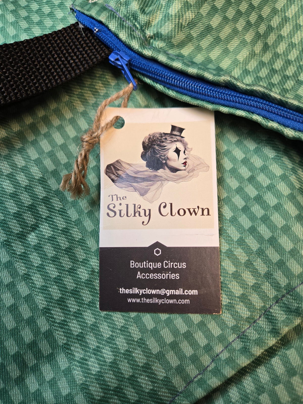 Handmade cloth gear bag with green check pattern, blue zipper, and hanging tag