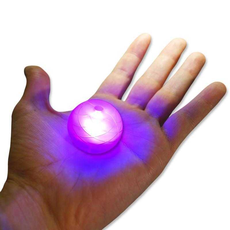 Translucent LED knob glowing purple on a hand for a fire poi
